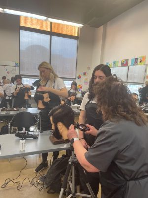 Cosmetology students studying and practicingtogether